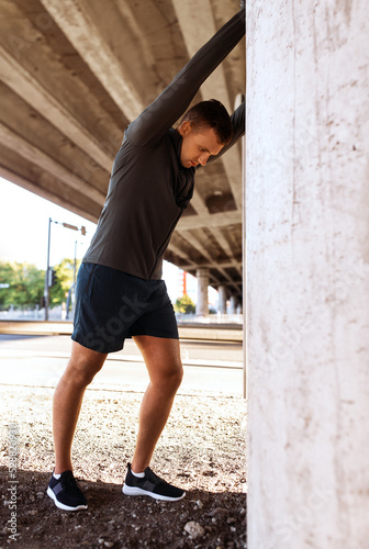 fitness, sport and healthy lifestyle concept - man stretching back under bridge