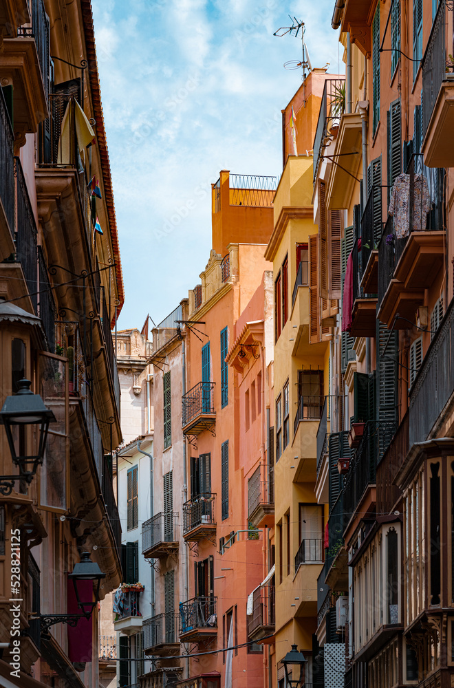 Narrow street with colorful buildings in the city of Palma de Mallorca, Spain, on the island of Mallorca. 