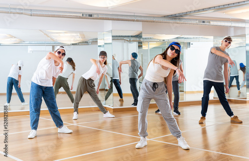 Teenagers boy and girls performing hip hop at group dance class