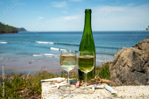 Tasting of txakoli or chacolí slightly sparkling very dry white wine produced in the Spanish Basque Country, served outdoor with view on Bay of Biscay, Atlantic Ocean.