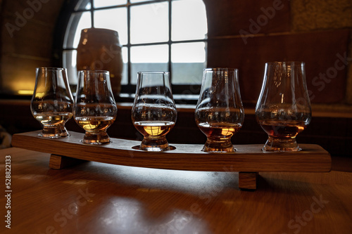 Flight of single malt scotch whisky in glasses served in whiskey bar in Edinburgh, UK