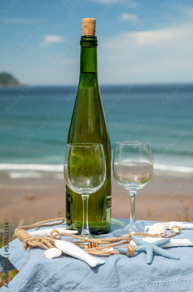 Tasting of txakoli or chacolí slightly sparkling very dry white wine produced in the Spanish Basque Country, served outdoor with view on Bay of Biscay, Atlantic Ocean. Tasting of txakoli or chacolí slightly sparkling very dry white wine produced in the Spanish Basque Country, served outdoor with view on Bay of Biscay, Atlantic Ocean.