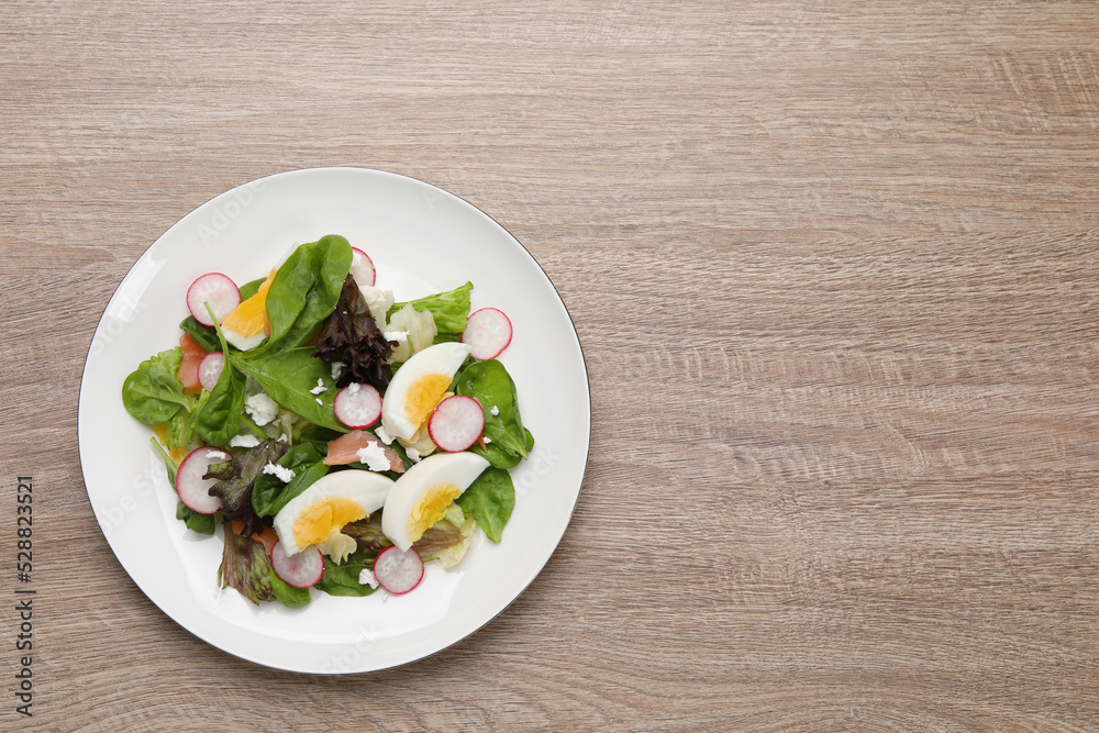 Delicious salad with boiled egg, radish and cheese on wooden table, top view. Space for text Delicious salad with boiled egg, radish and cheese on wooden table, top view. Space for text