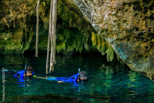 Some people is snorkeling on a cenote in Cancun Mexico