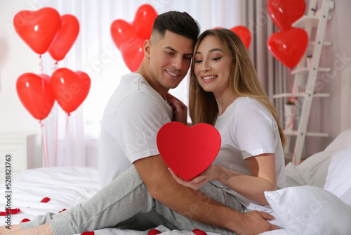 Lovely couple with gift in room. Valentine's day celebration