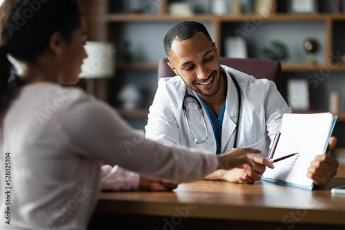 Print op canvas Handsome middle eastern doctor having conversation with black woman