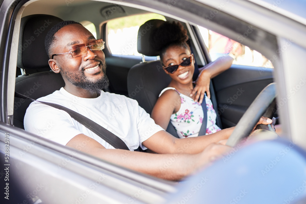 Happy black couple on road trip, bonding and discussing their holiday or vacation ahead. Cheerful African American man and woman enjoying time together, having fun on their driving adventure
