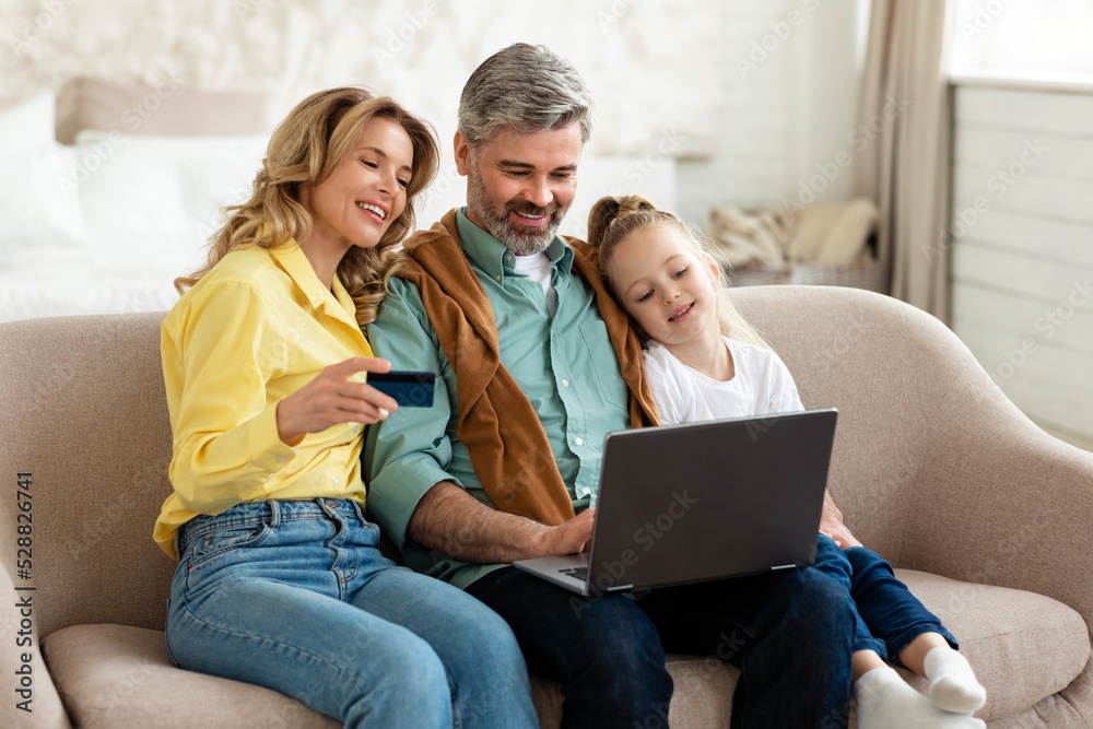 Family Holding Credit Card Using Laptop Making Payment Shopping Indoor