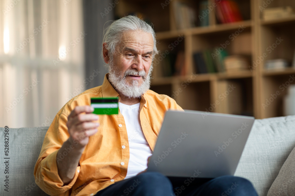 Excited senior man using laptop and credit card at home Excited senior man using laptop and credit card at home