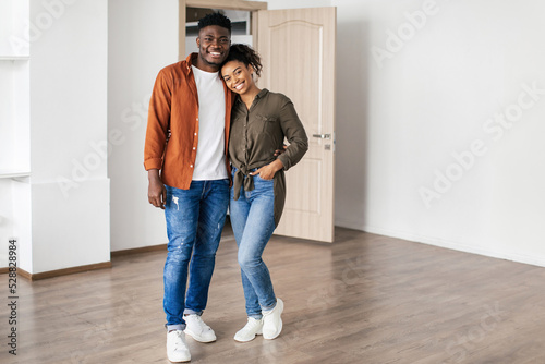 Couple Posing Embracing In Empty Living Room In New House