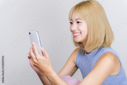 スマートフォンを使う金髪の女性