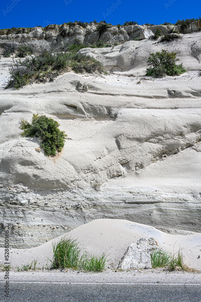 Erosion in sandstone rock cliff, tall grasses at the base, patterns and textures in nature as a background
Erosion in sandstone rock cliff, tall grasses at the base, patterns and textures in nature as a background