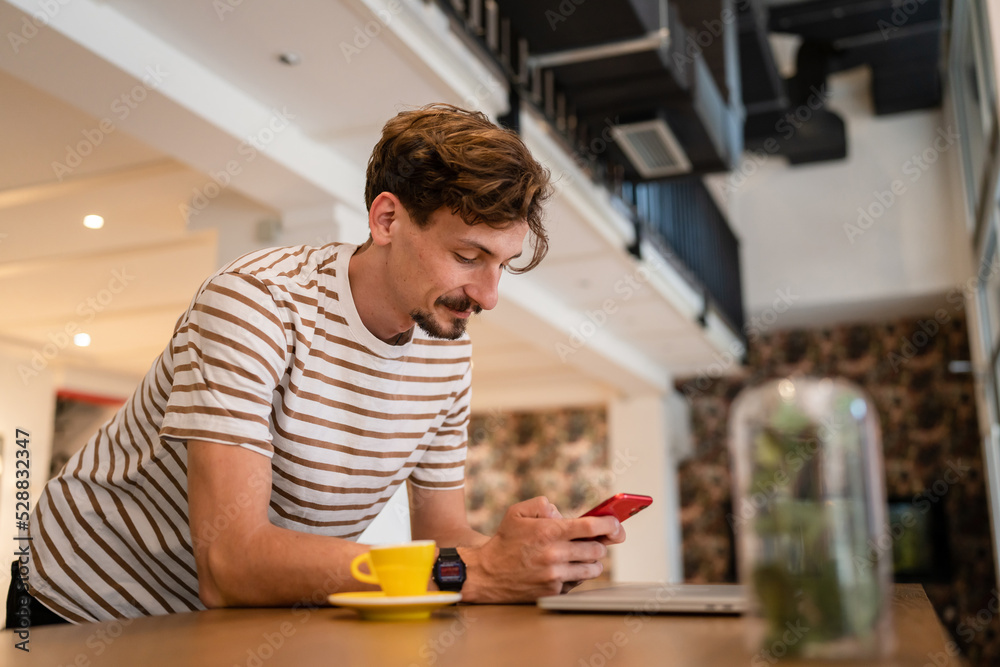 One modern caucasian man using mobile phone while stand at cafe One modern caucasian man using mobile phone while stand at cafe