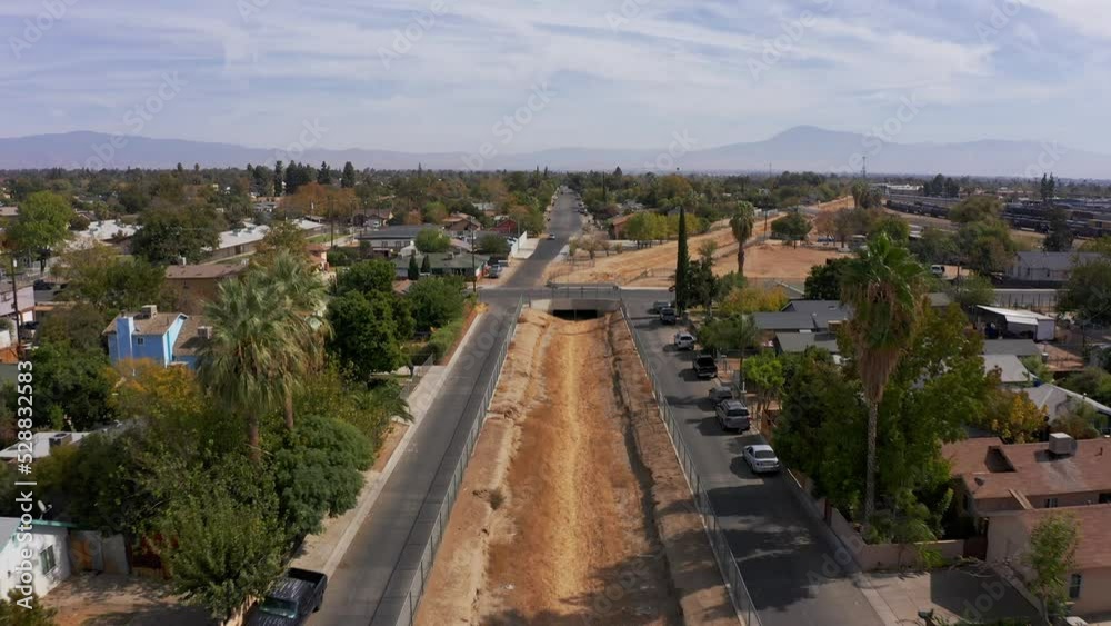 Low aerial shot flying over a dry canal in the suburbs of Bakersfield, California. 4K Low aerial shot flying over a dry canal in the suburbs of Bakersfield, California. 4K