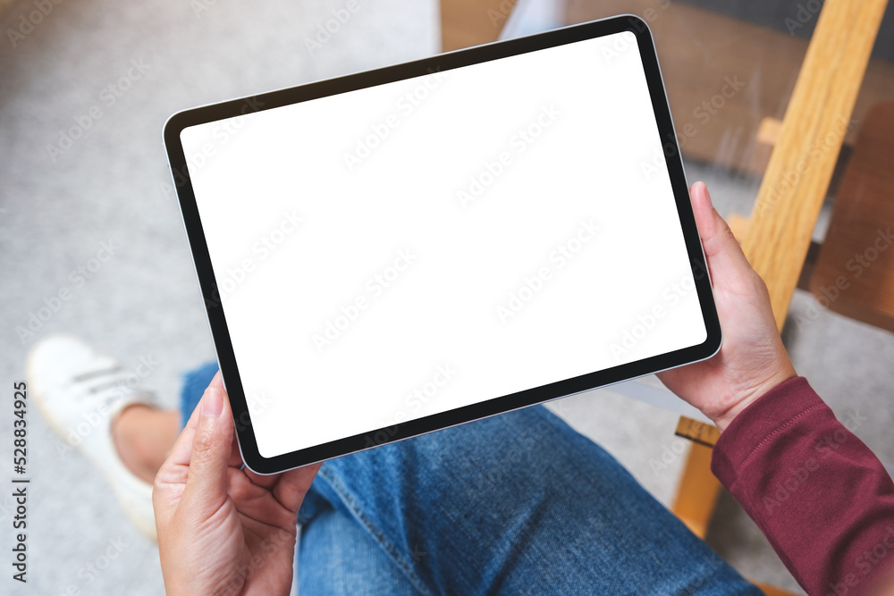 Top view mockup image of a woman holding digital tablet with blank white desktop screen Top view mockup image of a woman holding digital tablet with blank white desktop screen