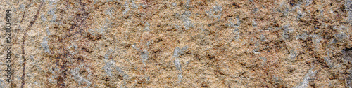 Closeup of an orange rock with tan patches, patterns and textures in nature as a background 