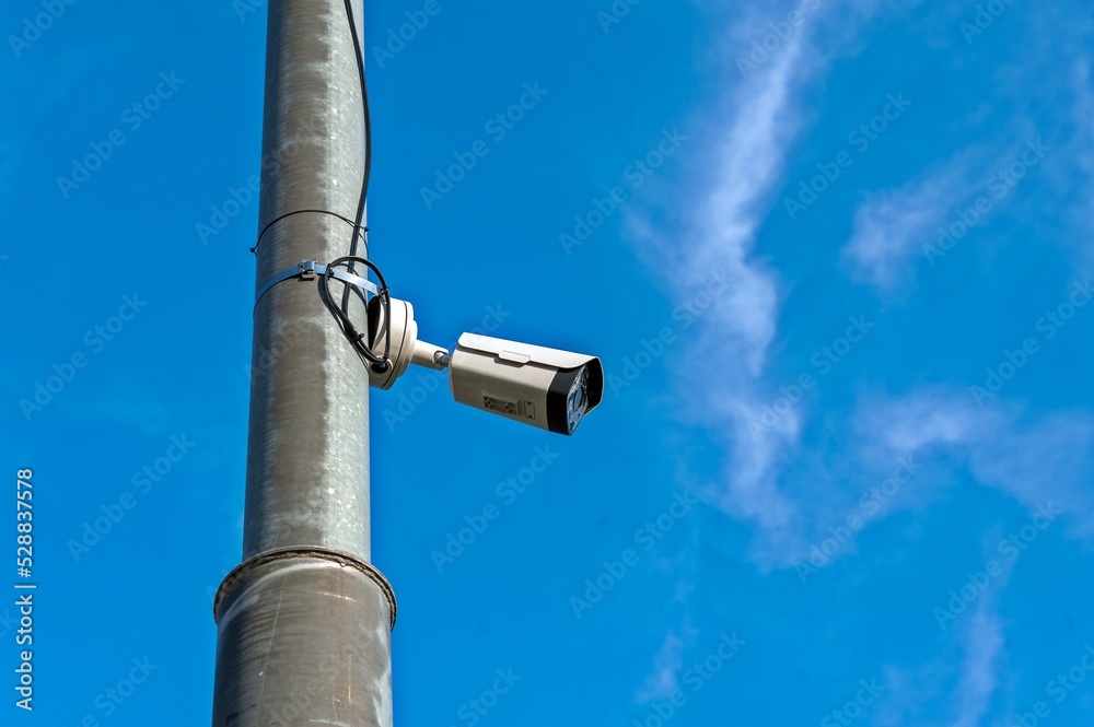A video camera for surveillance is hanging on a pole A video camera for surveillance is hanging on a pole