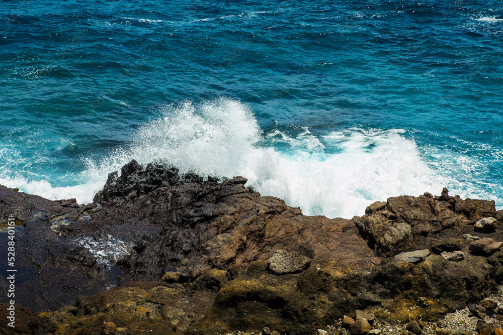 Offshore mountain rock and big wave hitting the shore Offshore mountain rock and big wave hitting the shore