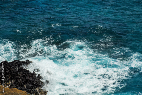 Offshore mountain rock and big wave hitting the shore