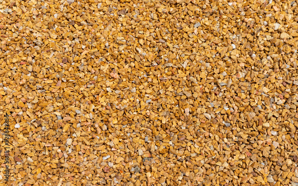 lose up of small stone texture. Abstract background of decorative floor, pebble stones. Gravel, yellow-orange road in the park. lose up of small stone texture. Abstract background of decorative floor, pebble stones. Gravel, yellow-orange road in the park.