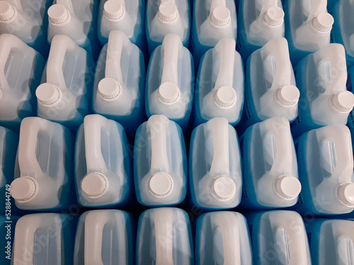 lots of white jerry cans filled with hand soap and sanitizer liquid in warehouse