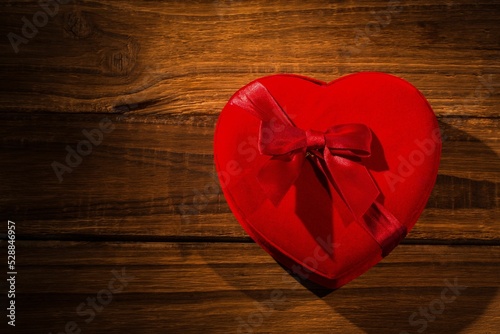 Red heart shaped pillow on wooden flooring