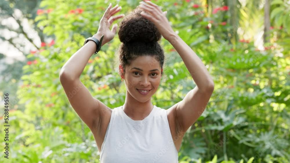 Natural beauty, hair and environment with a beautiful woman fixing her bun while standing outside in nature surrounded by green trees and fresh air. Portrait of Brazilian female outside for wellness