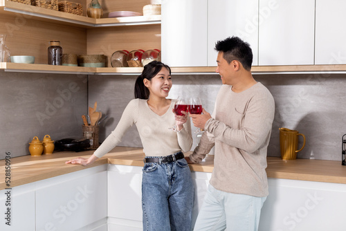 Happy korean spouses enjoying time together, drinking wine