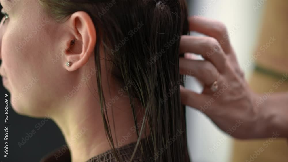 Close-up drying long hair with keratin treatment in beauty salon in slow motion. Unrecognizable hairdresser using dryer in hair parlor on long brunette hair of client Close-up drying long hair with keratin treatment in beauty salon in slow motion. Unrecognizable hairdresser using dryer in hair parlor on long brunette hair of client