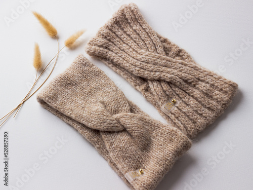 knitted headbands on a plain background with sprigs of decor