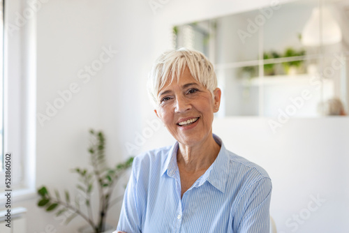 Senior woman looking at camera. Successful mature business woman . Happy old professor in standing in office with gray hair.