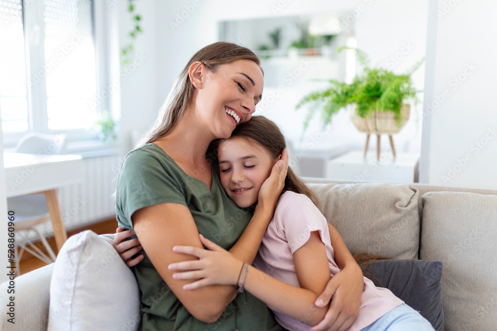 Portrait of happy young mother play hug and cuddle show love cute small preschooler daughter relaxing in living room, smiling mom and little girl child rest enjoy family weekend at home together Portrait of happy young mother play hug and cuddle show love cute small preschooler daughter relaxing in living room, smiling mom and little girl child rest enjoy family weekend at home together