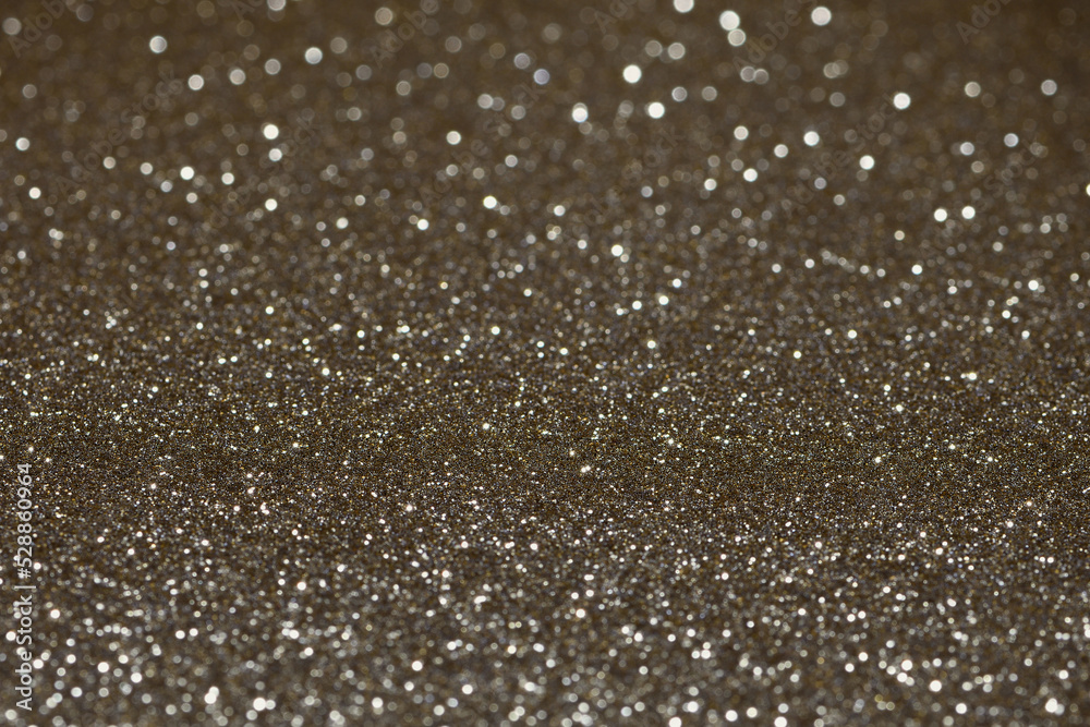 Extreme close-up flat piece of sparkly vibrant gold coloured craft paper shallow focal point