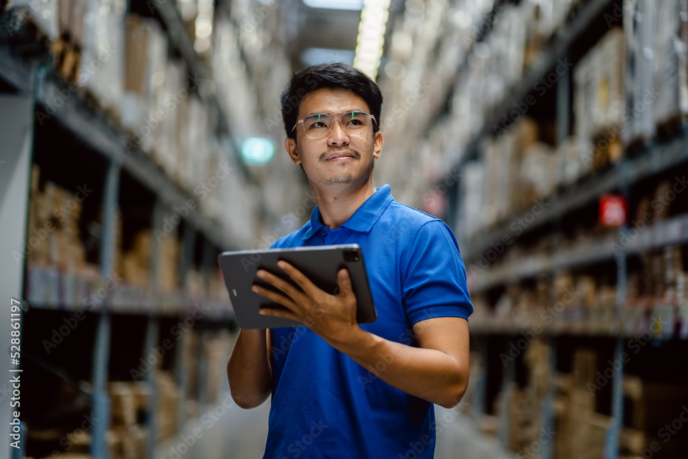 Warehouse Worker using digital tablets to check the stock inventory on