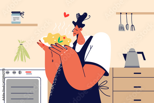 Happy man in apron cooking at home 