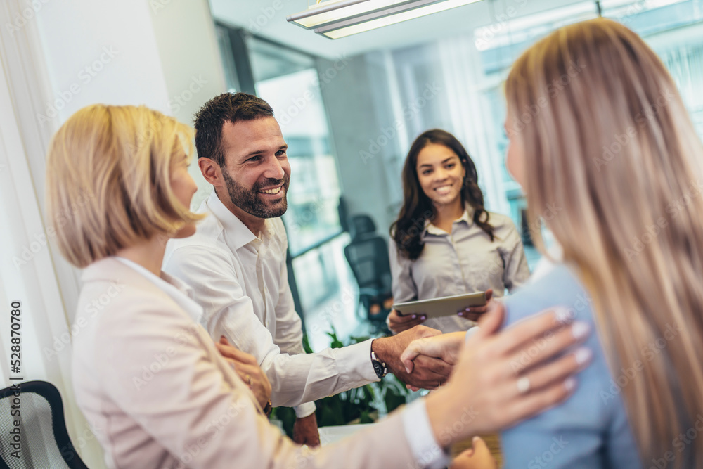 Shot of two businesspeople shaking hands during a meeting in an office Shot of two businesspeople shaking hands during a meeting in an office
