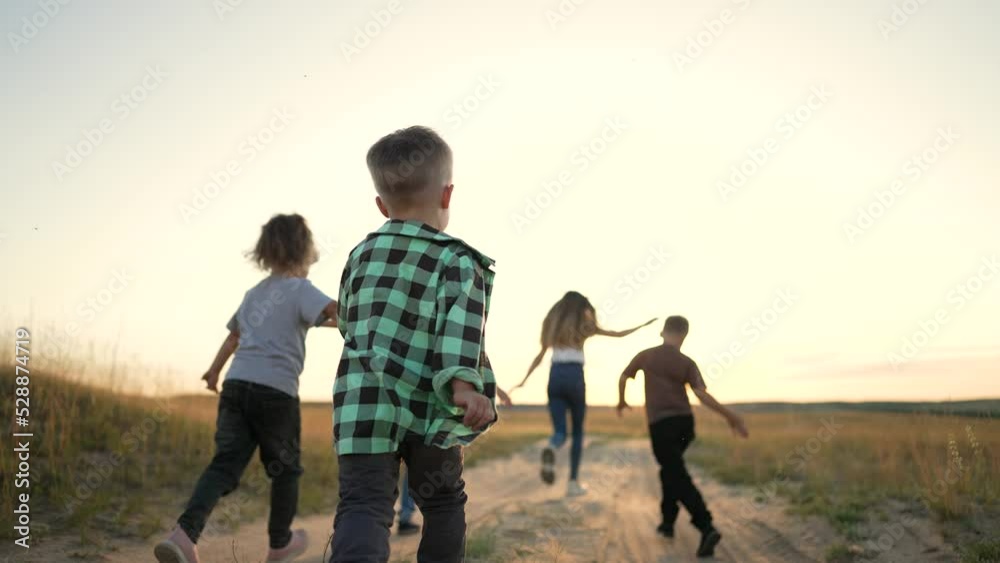 Happy children have fun play in spring in park.Group of children run cheerfully along path in field. Active people in nature. Happy children run together in park with smile. Friends walk on the grass Happy children have fun play in spring in park.Group of children run cheerfully along path in field. Active people in nature. Happy children run together in park with smile. Friends walk on the grass