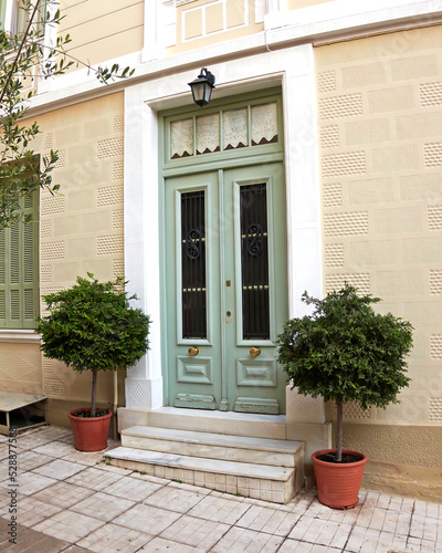 Cozy classic design house entrance olive green door and potted plants. Athens old town center, Greece. © Dimitrios