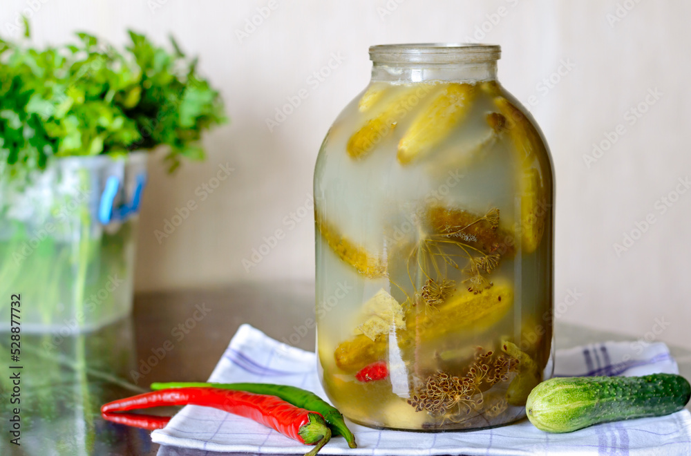 Healthy fermented food. Salt cucumbers in a glass jar with dill and peppers on the kitchen table. Healthy fermented food. Salt cucumbers in a glass jar with dill and peppers on the kitchen table.