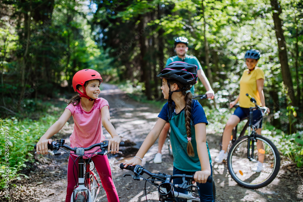 Young family with little children at bike trip together in nature.