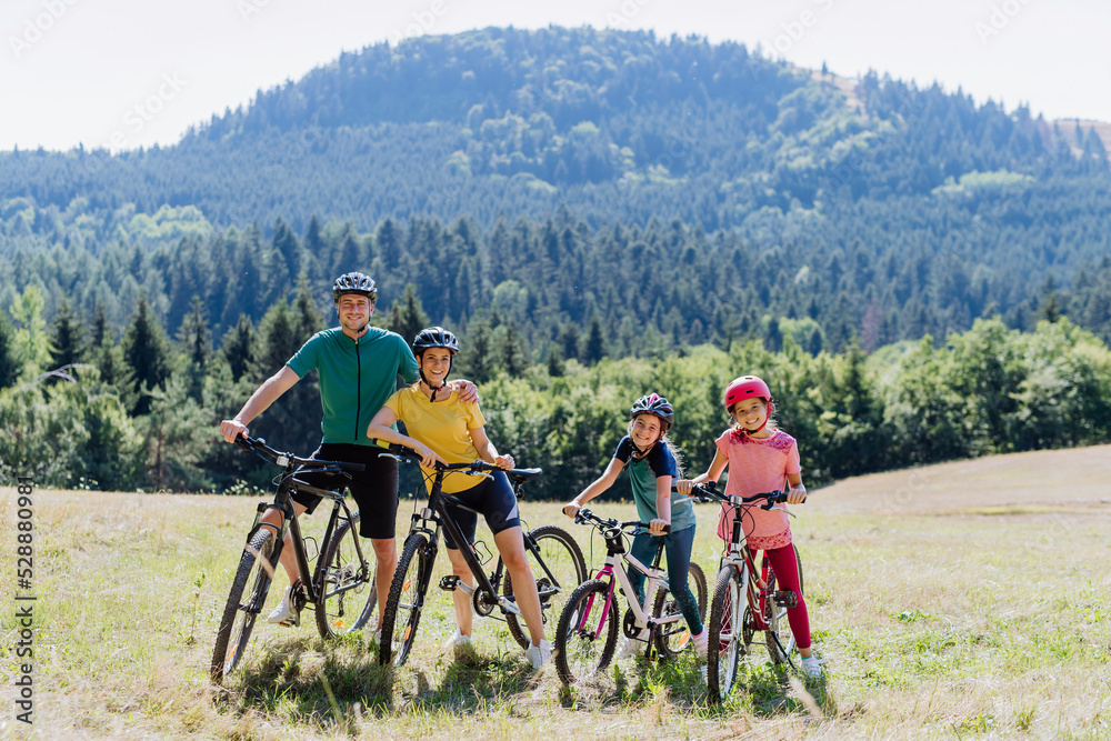 Obraz premium Young family with children at bike trip,posing with bicycles in nature.