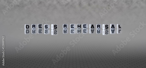 dress rehearsal word or concept represented by black and white letter cubes on a grey horizon background stretching to infinity