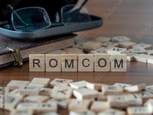 Konstfotografi romcom word or concept represented by wooden letter tiles on a wooden table with