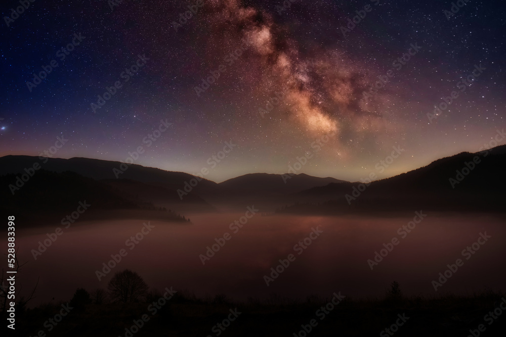 Night in the autumn mountains. Starry sky, yellow leafy trees and fog. Night in the autumn mountains. Starry sky, yellow leafy trees and fog.