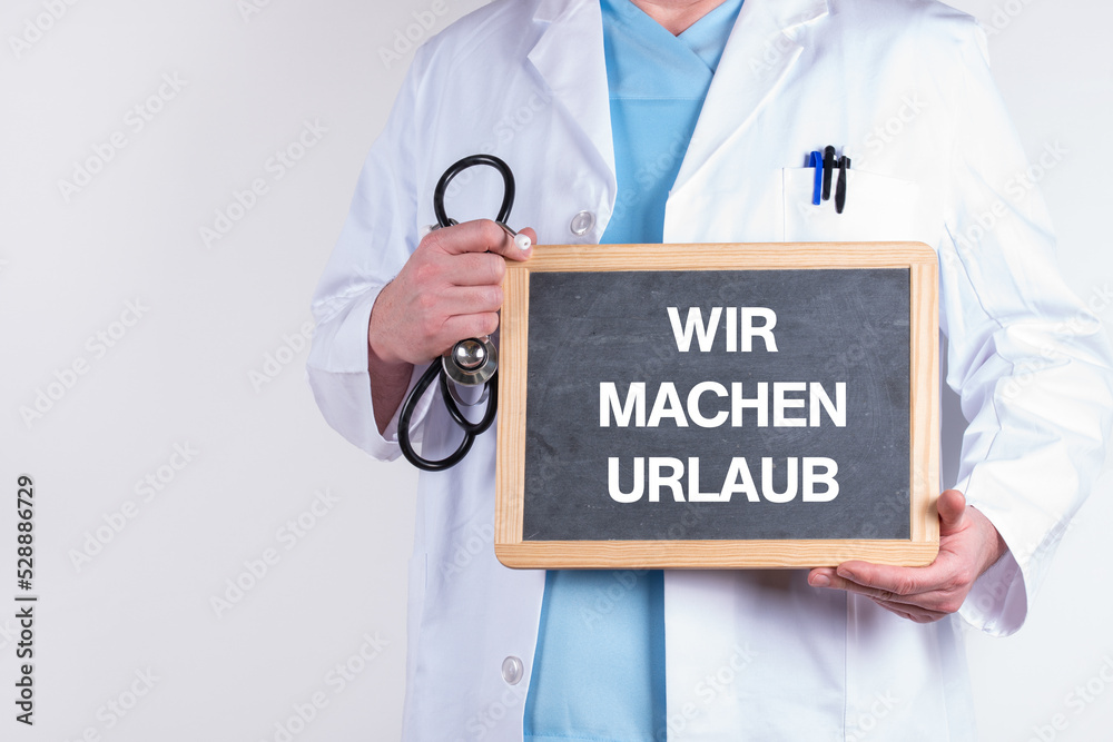 Arzt mit einer Tafel auf der WIR MACHEN URLAUB steht Arzt mit einer Tafel auf der WIR MACHEN URLAUB steht