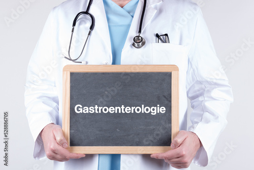 Arzt mit einer Tafel auf der Gastroenterologie steht photo