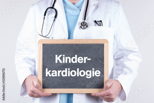 Arzt mit einer Tafel auf der Kinderkardiologie steht