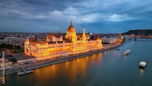 illuminated Hungarian Parliament Building with the Danube river, after sunset in Budapest, Hungary. 4K aerial drone view