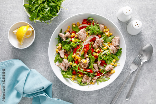 Foto Canned tuna salad with arugula and fresh vegetables, top view