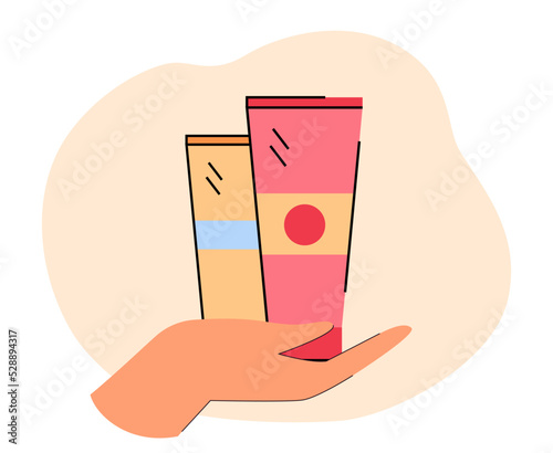 Human hand holding tubes with hand or facial cream. Person with cosmetic products flat vector illustration. Beauty, skincare, cosmetology concept for banner, website design or landing web page